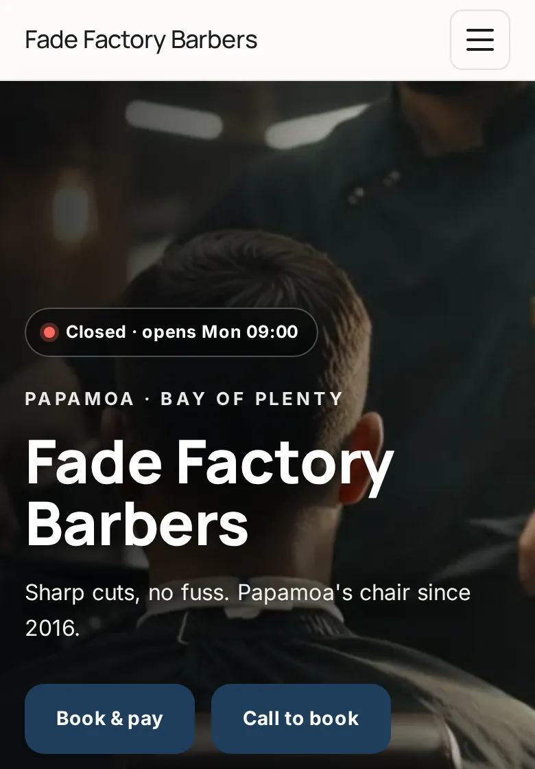 Clean style barbershop website on a phone: white header, modern type and navy buttons